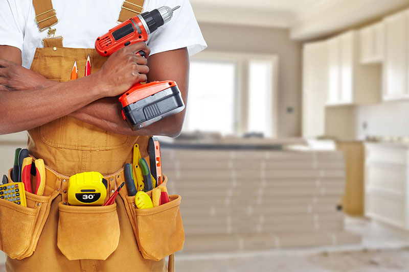 A home service man is standing with construction tools for the home renovation task.