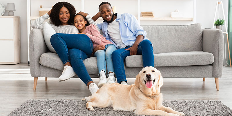 Happy family resting in home with dog