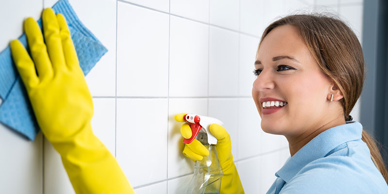 Woman cleaning grout and tile