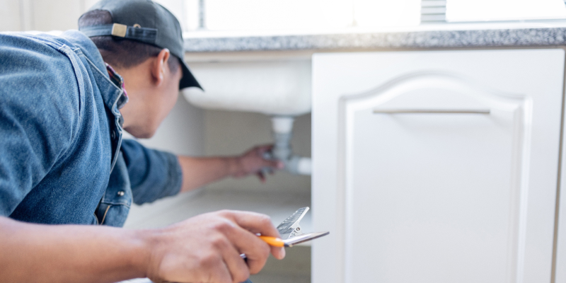 A plumbing technician with a checklist inpsecting the types of plumbing services done in a house.